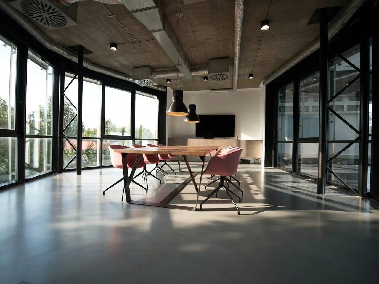 Sunlit workspace with a meeting table and glass partitions